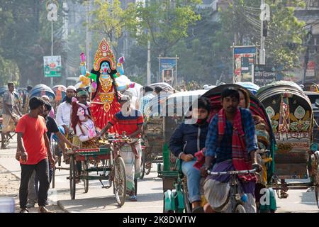 Narayanganj, Dhaka, Bangladesch. 23. Oktober 2022. Eifrige Anhänger transportieren ein Idol der Hindu-Göttin Kali auf einem Rikscha-Van zu einem Ort der Anbetung vor dem Shyama Puja-Fest in Narayanganj, Bangladesch. Die Göttin Kali wird als Retter von aller bösen Kraft, von Dämonen und einer Quelle der Macht, von Glück, wie es die Hindu-Mythologie darstellt, verehrt. (Bild: © Joy Saha/ZUMA Press Wire) Stockfoto