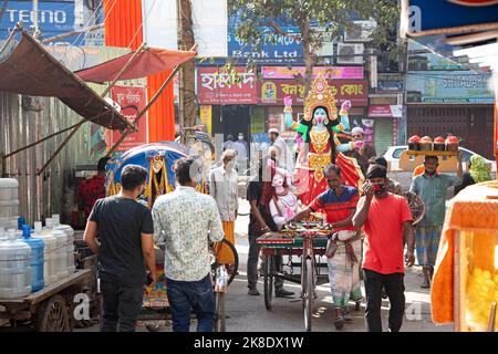 Narayanganj, Dhaka, Bangladesch. 23. Oktober 2022. Eifrige Anhänger transportieren ein Idol der Hindu-Göttin Kali auf einem Rikscha-Van zu einem Ort der Anbetung vor dem Shyama Puja-Fest in Narayanganj, Bangladesch. Die Göttin Kali wird als Retter von aller bösen Kraft, von Dämonen und einer Quelle der Macht, von Glück, wie es die Hindu-Mythologie darstellt, verehrt. (Bild: © Joy Saha/ZUMA Press Wire) Stockfoto