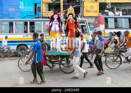 Narayanganj, Dhaka, Bangladesch. 23. Oktober 2022. Eifrige Anhänger transportieren ein Idol der Hindu-Göttin Kali auf einem Rikscha-Van zu einem Ort der Anbetung vor dem Shyama Puja-Fest in Narayanganj, Bangladesch. Die Göttin Kali wird als Retter von aller bösen Kraft, von Dämonen und einer Quelle der Macht, von Glück, wie es die Hindu-Mythologie darstellt, verehrt. (Bild: © Joy Saha/ZUMA Press Wire) Stockfoto