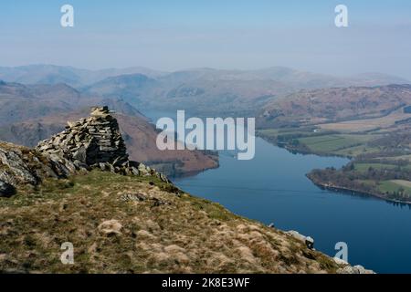 Wundervolle Aussicht auf ein Cairn an den Hängen von Arthur's Pike Fell, mit Blick auf Ullswater im englischen Lake District Stockfoto