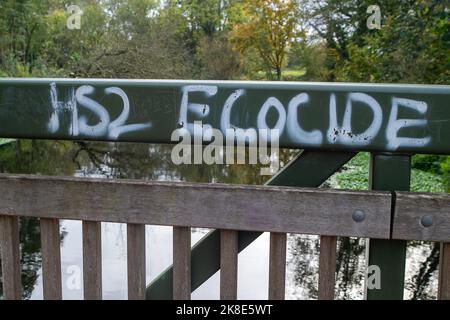 Denham, Uxbridge, Großbritannien. 22.. Oktober 2022. HS2 Ökozid-Graffiti auf einer Brücke im Colne Valley Park, wo HS2 im Rahmen des Projekts High Speed 2 Rail eine große Baumschar zerstört haben. Die Phase 1 des Projekts HS2 liegt laut Berichten deutlich über dem Budget, und das Finanzministerium hat eine finanzielle Überprüfung beantragt. Umweltschützer setzen ihren Kampf für die Annullierung von HS2 fort. Quelle: Maureen McLean/Alamy Live News Stockfoto