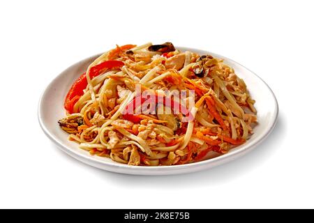 Teller mit chinesischen gebratenen udon-Nudeln mit Garnelen, Muscheln, Tintenfisch, Karotten und Paprika Stockfoto