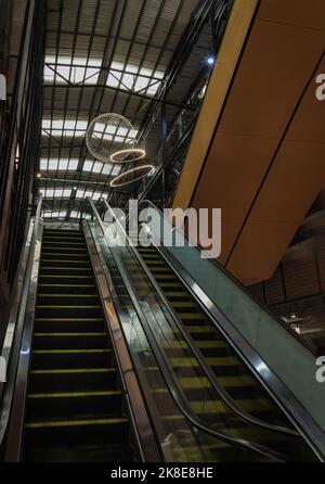Bangkok, Thailand - Oct 10, 2022 : Architekturdesign modernes Interieur des Gebäudes dekorativ mit kreisförmiger Pendelleuchte über Rolltreppen. Selecti Stockfoto