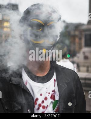 Ein maskierter Demonstrante, wie London, steht in Solidarität mit regierungsfeindlichen Demonstrationen im Iran. Stockfoto