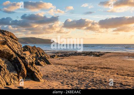 Schönes Landschaftsbild im Sommer bei Sonnenuntergang von Widemouth Bay in Devon England mit goldenem Stundenlicht am Strand Stockfoto