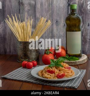 Ein köstlicher Teller mit Spaghetti mit Tomaten, Basilikum und nativem Olivenöl extra, ein typisch italienisches Rezept Stockfoto