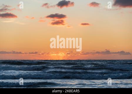 Schönes Landschaftsbild im Sommer bei Sonnenuntergang von Widemouth Bay in Devon England mit goldenem Stundenlicht am Strand Stockfoto