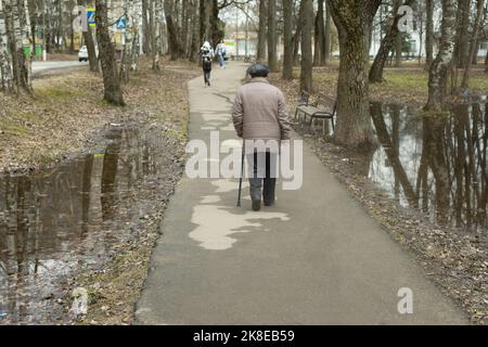 Alte Frau auf der Straße. Rentner mit Gehstock. Mann im Park. Stockfoto