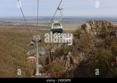 Thale, Deutschland. 23. Oktober 2022. Gondeln der Seilbahn schweben über dem Bode-Tal. Das sonnige Wetter zog wieder viele Besucher in den Harz. Die Betreiber der Bergbahnen und Skilifte im Harz erleben an diesem Wochenende mit Beginn der Herbstferien eine hohe Besucherzahl. Quelle: Matthias Bein/dpa/Alamy Live News Stockfoto