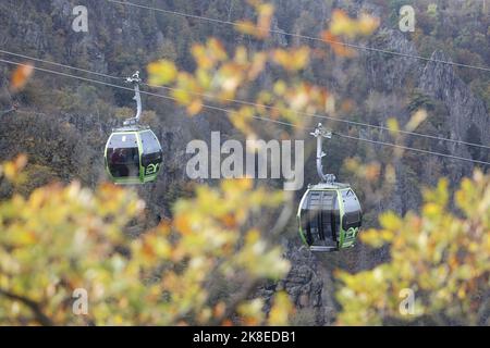 Thale, Deutschland. 23. Oktober 2022. Gondeln der Seilbahn schweben über dem Bode-Tal. Das sonnige Wetter zog wieder viele Besucher in den Harz. Die Betreiber der Bergbahnen und Skilifte im Harz erleben an diesem Wochenende mit Beginn der Herbstferien eine hohe Besucherzahl. Quelle: Matthias Bein/dpa/Alamy Live News Stockfoto