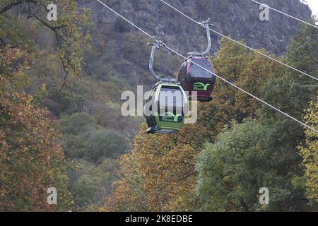 Thale, Deutschland. 23. Oktober 2022. Gondeln der Seilbahn schweben über dem Bode-Tal. Das sonnige Wetter zog wieder viele Besucher in den Harz. Die Betreiber der Bergbahnen und Skilifte im Harz erleben an diesem Wochenende mit Beginn der Herbstferien eine hohe Besucherzahl. Quelle: Matthias Bein/dpa/Alamy Live News Stockfoto