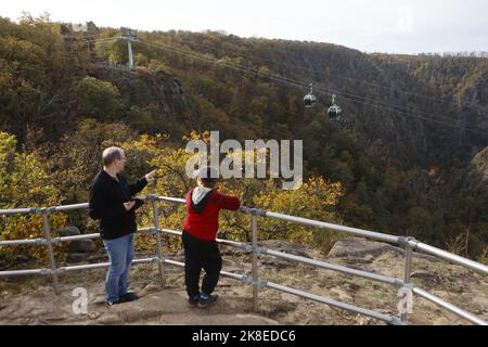 Thale, Deutschland. 23. Oktober 2022. Gondeln der Seilbahn schweben über dem Bode-Tal. Das sonnige Wetter zog wieder viele Besucher in den Harz. Die Betreiber der Bergbahnen und Skilifte im Harz erleben an diesem Wochenende mit Beginn der Herbstferien eine hohe Besucherzahl. Quelle: Matthias Bein/dpa/Alamy Live News Stockfoto