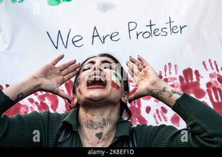 Ein gesichtsbemalter Demonstranten sah während des Protestes schreiende Slogans. Nach dem Tod von Mahsa Amini organisierten Demonstranten eine Demonstration. Mahsa fiel ins Koma und starb, nachdem er in Teheran von der Moralpolizei verhaftet worden war, weil er angeblich die Hijab-Regeln des Landes verletzt hatte. Aminis Tod hat Wochen gewaltsamer Proteste im ganzen Iran ausgelöst. Stockfoto