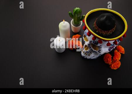 Dia de muertos - Tag des toten Altars Konzept. Zusammensetzung von Zuckerschädeln, weißen Kerzen und Blumen, Stockfoto