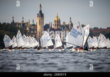 Schwerin, Deutschland. 23. Oktober 2022. Segler der Juniorbootklasse 'Optimist' segeln beim Herbstcup am Schweriner See vor dem Schweriner Schloss. Mehr als 400 Segler in verschiedenen Klassen sind zum Saisonabschluss der Segler auf dem Wasser. Quelle: Michael Kappeler/dpa/Alamy Live News Stockfoto