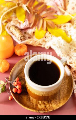 Zusammensetzung Herbstblätter, heiße Tasse Kaffee und warmes Tuch. Herbstliches Frühstück. Gemütliches Herbstkonzept. Stockfoto