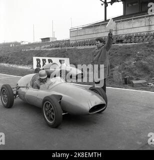 1959, historisch, Motorsport, Cooper Driving School, ein Rennfahrer in einem offenen, einsitzigen, einer Formula Cooper Junior. Auf der Rennstrecke in Brands Hatch, Kent, England, Großbritannien, kurz vor dem Start. Beamter mit dem Auto, der eine kleine Klemmtafel hält. Coopers, ein legendärer Name im Motorsport, erreichte 1959 & 1960 als Formel-1-Konstruktor-Weltmeister das höchste Niveau und war der erste Sieger in einem Heckmotor. Zu dieser Zeit war die in Großbritannien ansässige Cooper Car Company der weltweit größte Spezialhersteller von Rennwagen und ihr „Mini Cooper“ war führend Stockfoto