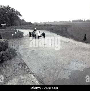 1962, historisch, ein einsitziger Rennwagen auf der schmalen Rennstrecke, die umfahrende Straße bei Finmere Aerodome, einem stillstehenden RAF-Flugplatz in der Nähe von Buckingham, England, Großbritannien, wo Geoff Clarke's Motor Racing Stables beheimatet ist. Die 1.000-ccm-Einsitzer der Rennschule waren Formel-Junior-Coopers mit Heckmotor. Stockfoto