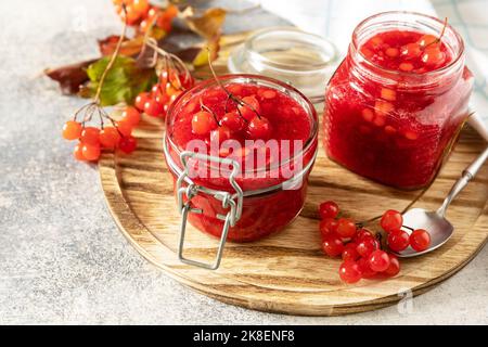 Frische reife Viburnum-Beere mit Zucker zur Zubereitung von Vitamin- und antioxidativem Tee auf einem Steintisch. Quelle von natürlichen Vitaminen. Wird in der Volksmedizin verwendet. Stockfoto