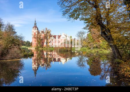 Bad Muskau, Deutschland. 23. Oktober 2022. Das Neue Schloss im Fürst-Pückler-Park spiegelt sich in einem Teich in der Sonne wider. Der rund 800 Hektar große Landschaftspark im englischen Stil in der Oberlausitz ist ein beliebtes Ausflugsziel. Quelle: Frank Hammerschmidt/dpa/Alamy Live News Stockfoto