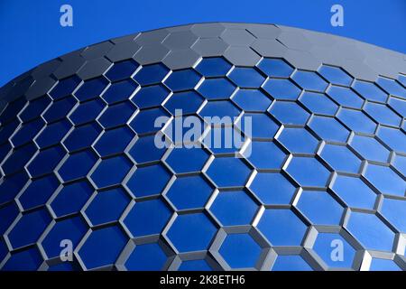 Wabenblaue Glasfenster. Teil einer verglasten Fassade eines modernen Gebäudes. Stadtraum. Stockfoto