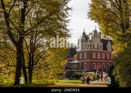 Bad Muskau, Deutschland. 23. Oktober 2022. Bei sonnigem Herbstwetter sind Wanderer auf dem Neuen Schloss im Prinz-Pückler-Park in Bad Muskau auf dem Vorplatz. Ein beliebtes Ausflugsziel ist der rund 800 Hektar große Landschaftspark im englischen Stil in der Oberlausitz. Quelle: Frank Hammerschmidt/dpa/Alamy Live News Stockfoto