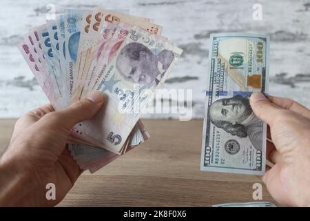 Wechseln Sie Geld, Mann hält Dollar und türkische Lira mit den Händen. Stockfoto