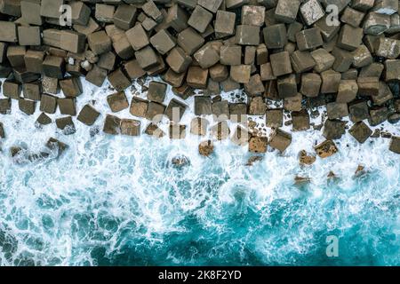 Lufttrohne Ansicht eines Betonbruchs. Wellenbrecher im Meer. Blaues Atlantisches Meer von oben. Stockfoto