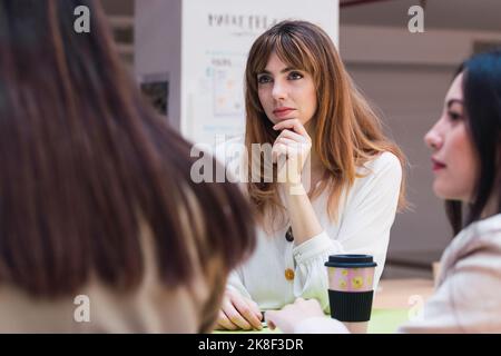 Geschäftsfrau, die Kollegen während eines Meetings im Büro zuhört Stockfoto