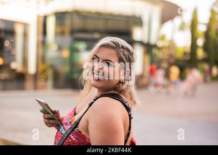 Glückliche junge Frau mit Mobiltelefon Stockfoto