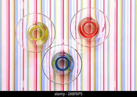 Rote, gelbe und blaue Schalen auf Streifenmuster Stockfoto