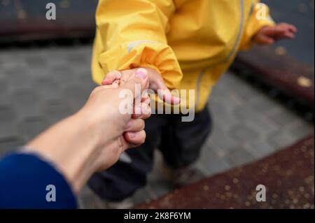 Mutter hält die Hand des Sohnes am Park Stockfoto