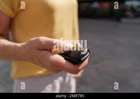 Hand einer reifen Frau, die den Schlüssel hält Stockfoto
