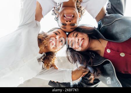 Glückliche junge multirassische Freunde, die sich zusammenhusten Stockfoto