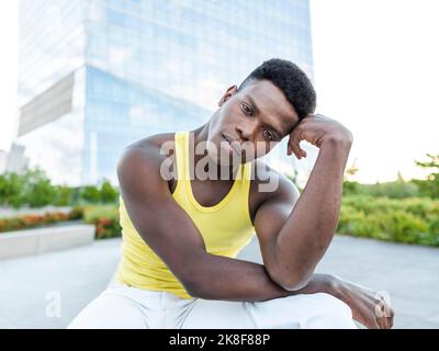 Junger Mann mit gelber Weste vor dem modernen Gebäude Stockfoto