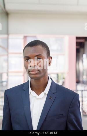 Junger Geschäftsmann, der am Bahnhof steht Stockfoto