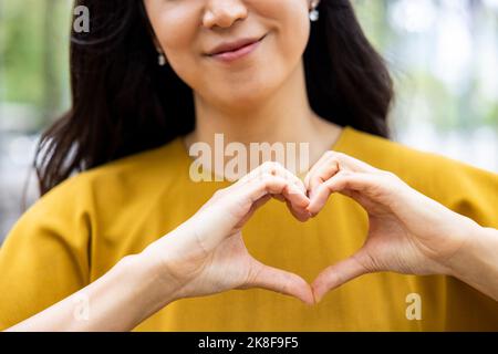 Hände einer Frau, die Herzform macht Stockfoto