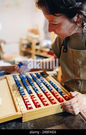 Unternehmer mit Briefmarkenschachtel, der in der Keramikwerkstatt arbeitet Stockfoto