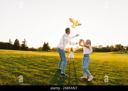 Vater und Tochter fliegen Drachen zusammen im Park Stockfoto