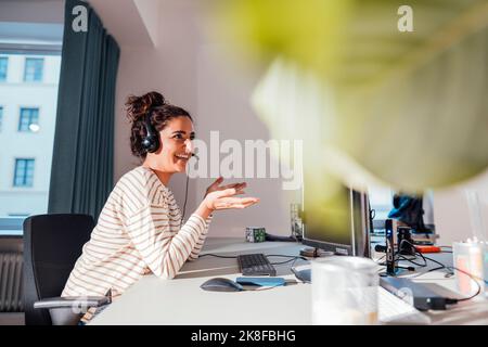 Lächelnder Kundendienstmitarbeiter, der an der Rezeption im Büro arbeitet Stockfoto