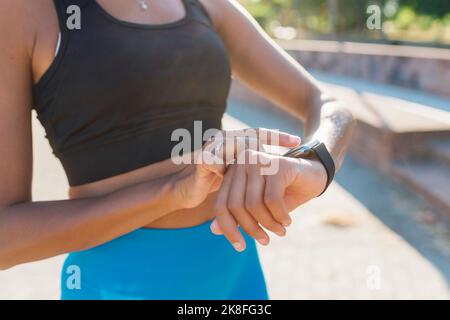 Junge Sportlerin überprüft Smart Watch Stockfoto