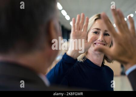 Glückliche Geschäftsfrau, die Kollegen fünf Punkte gibt Stockfoto