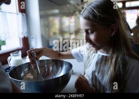 Mädchen, die Zutaten in einer Schüssel mischen Stockfoto
