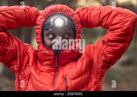 Junge Frau mit Taschenlampe auf der Stirn Stockfoto