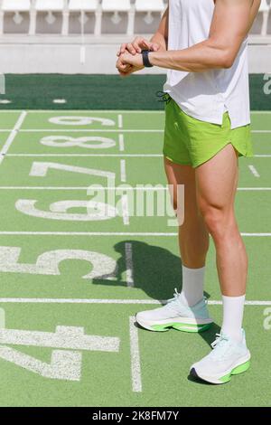 Sportler mit intelligenter Uhr auf der Laufstrecke Stockfoto