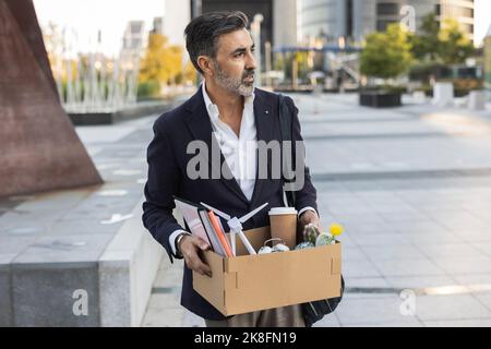 Gefeuert Geschäftsmann hält Bürobedarf in Box Stockfoto