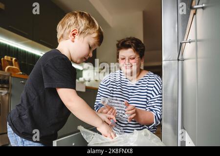 Mutter und Sohn sortieren Plastikmüll in der Küche zu Hause Stockfoto