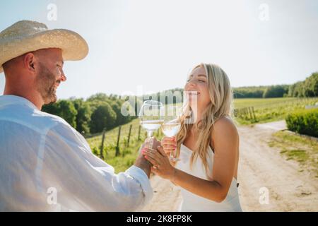 Glückliches Paar, das Spaß mit Weinglas im Weingut hat Stockfoto