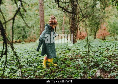 Mädchen trägt übergroßen Pullover und Spaziergang im Wald Stockfoto