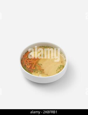 Frische Hühnersuppe mit Ei und Gemüse in einer Schüssel auf weißem Hintergrund Stockfoto